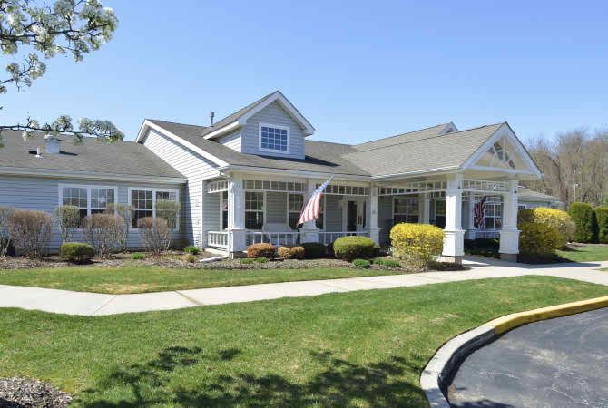 A suburban residential house with a well-kept lawn and porch.
