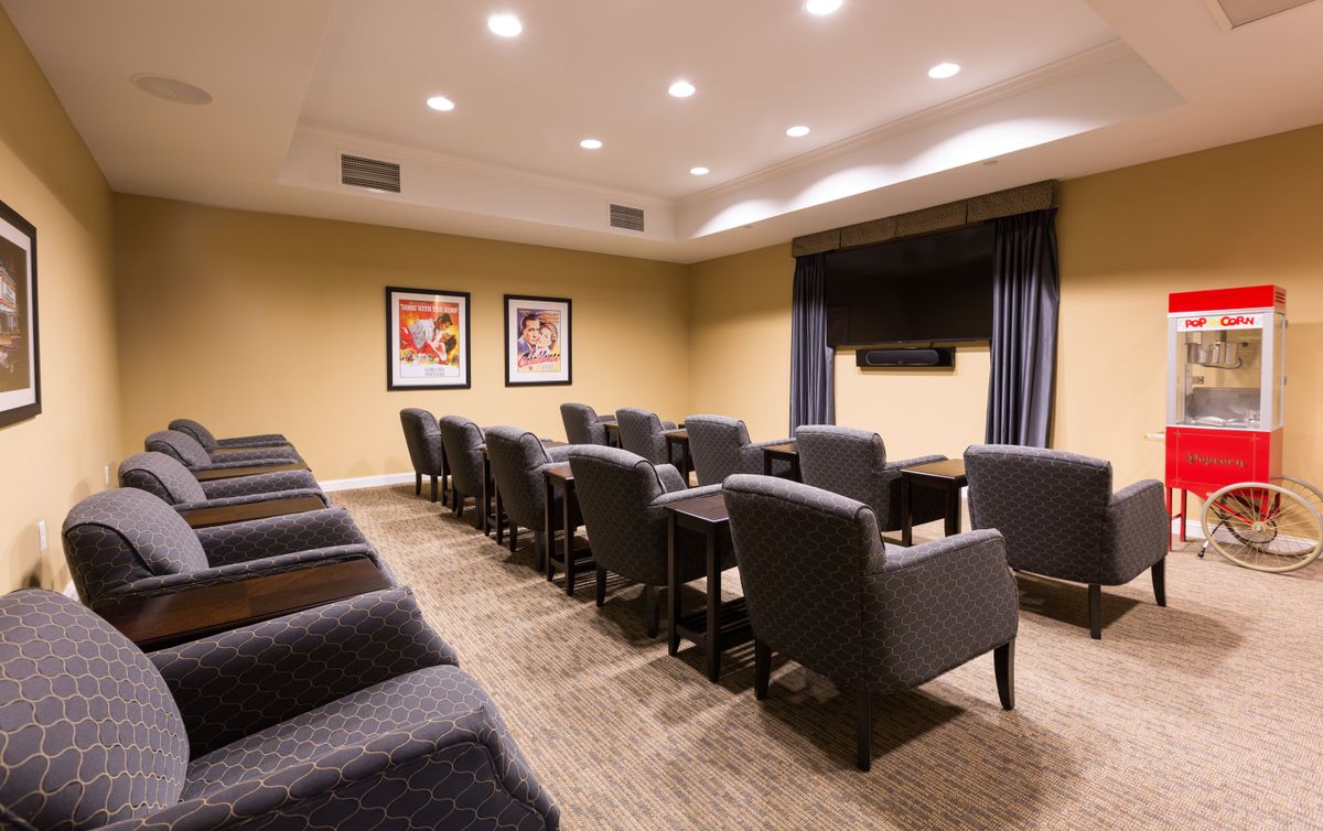 A modern conference room with rows of comfortable seating facing a television.