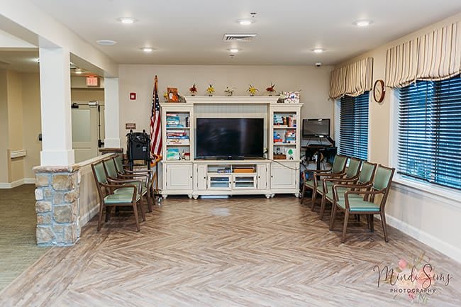 A well-organized waiting area featuring a television and an American flag, surrounded by arranged seating.