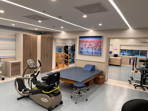A well-equipped physical therapy room featuring exercise equipment and therapeutic spaces.