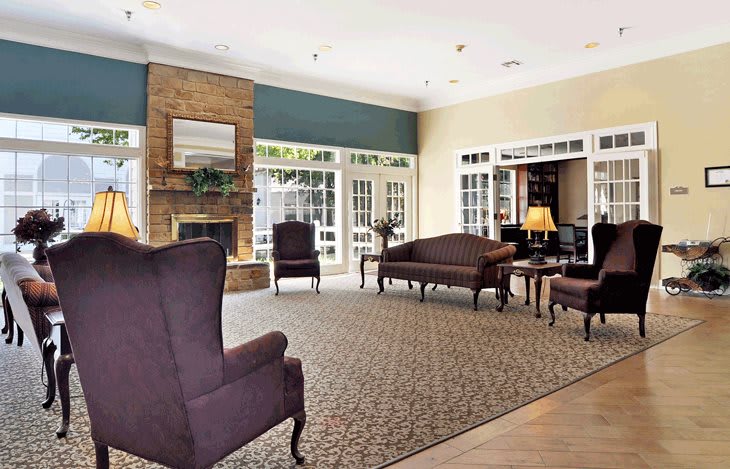 A spacious lobby featuring elegant furniture and a warm fireplace.