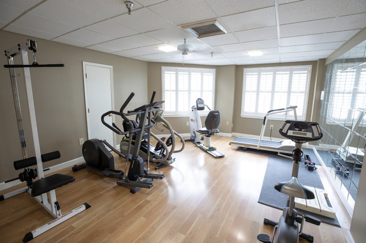 A small home gym with various exercise equipment including a treadmill and elliptical machine.