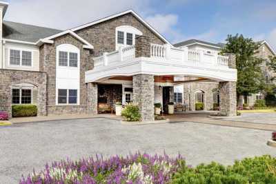 A modern residential building with stone facade and landscaped surroundings.