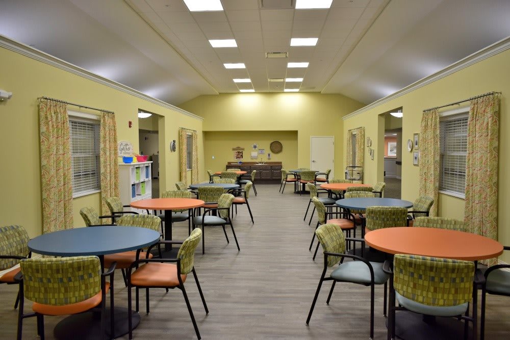 A bright, open community dining area with colorful tables and chairs.
