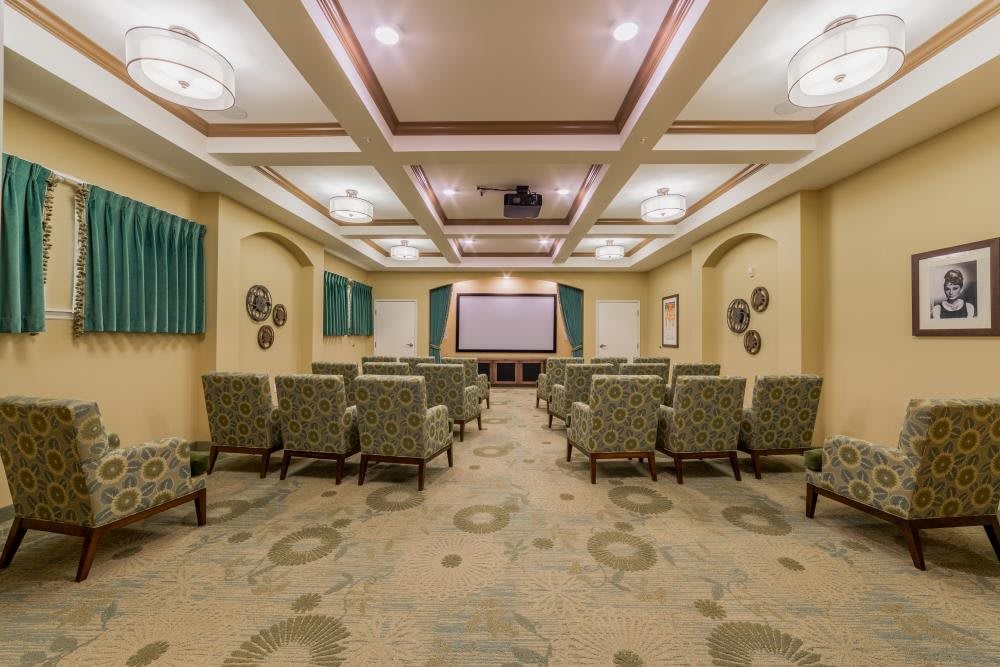 A spacious theater-style room with arranged seating and a large projection screen.