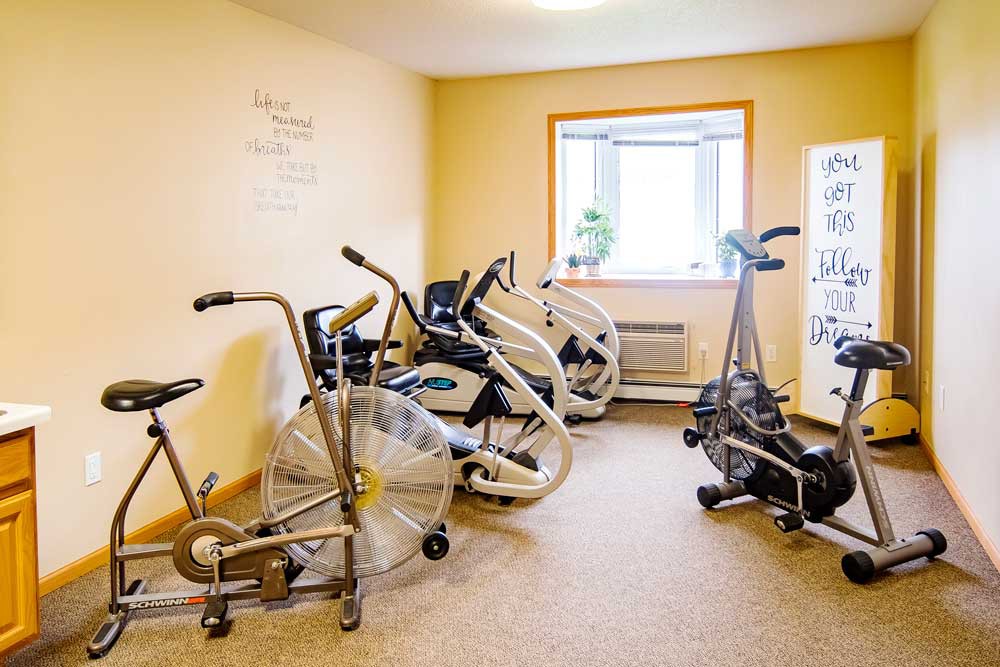A well-lit exercise room with several stationary bikes for indoor workouts.