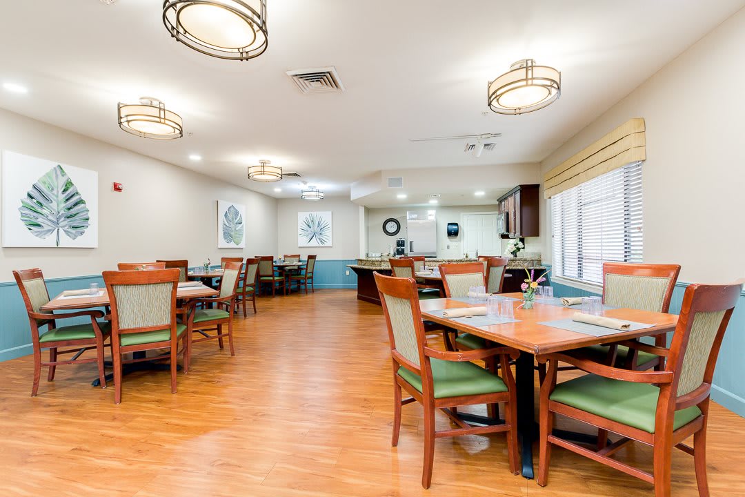 A spacious and well-lit dining room with neatly arranged tables and chairs.
