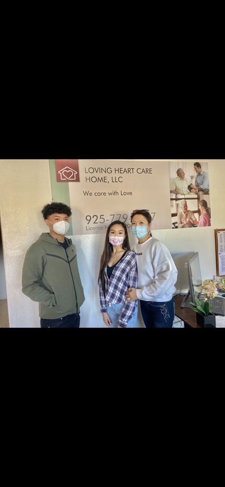 Three people wearing masks are standing together in front of a healthcare home sign.