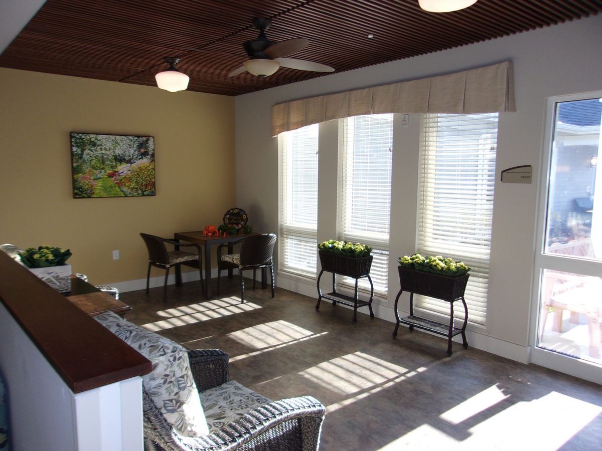 A bright sunroom with wicker furniture and large windows allowing abundant natural light.