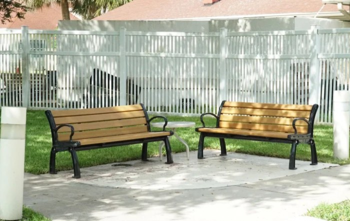 Two wooden benches in a sunny outdoor park area.