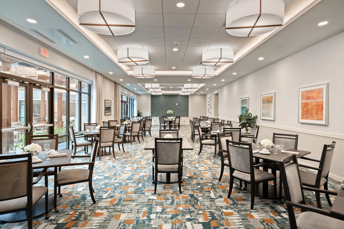 A spacious and well-lit dining room with arranged tables and chairs.
