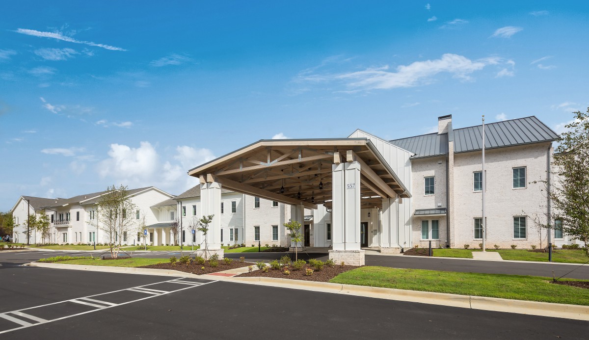 A modern residential building with a covered entrance and well-maintained landscaping.