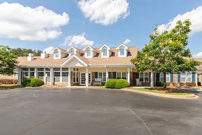 A suburban residential building with a clear sky and fluffy clouds overhead.