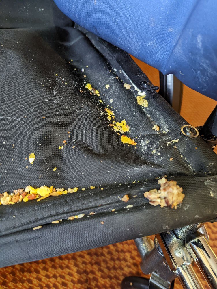 A chair covered in spilled food and crumbs.