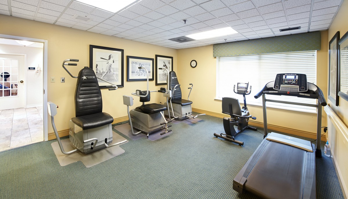 A well-equipped fitness room with various exercise machines and equipment.