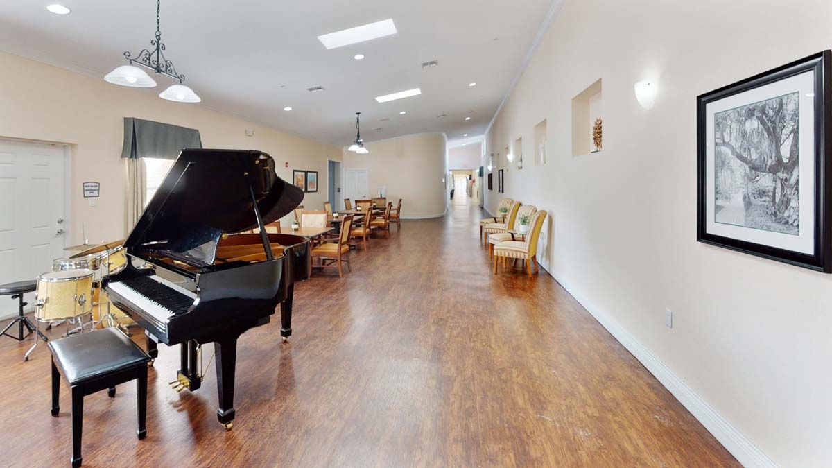 A spacious hallway with a grand piano and modern seating arrangements.