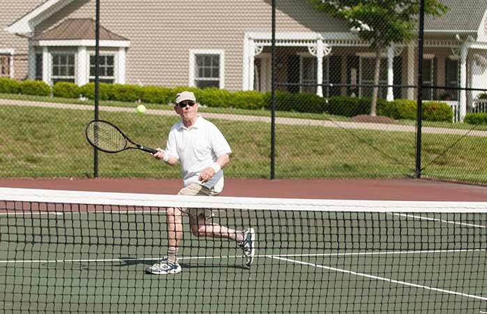A person playing tennis on an outdoor court.