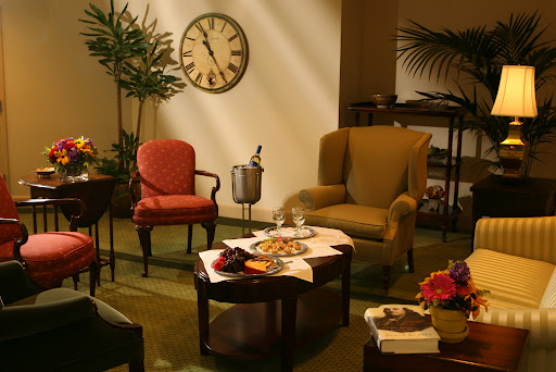 A cozy living room setup featuring a clock, comfortable chairs, and a decorative table with snacks.