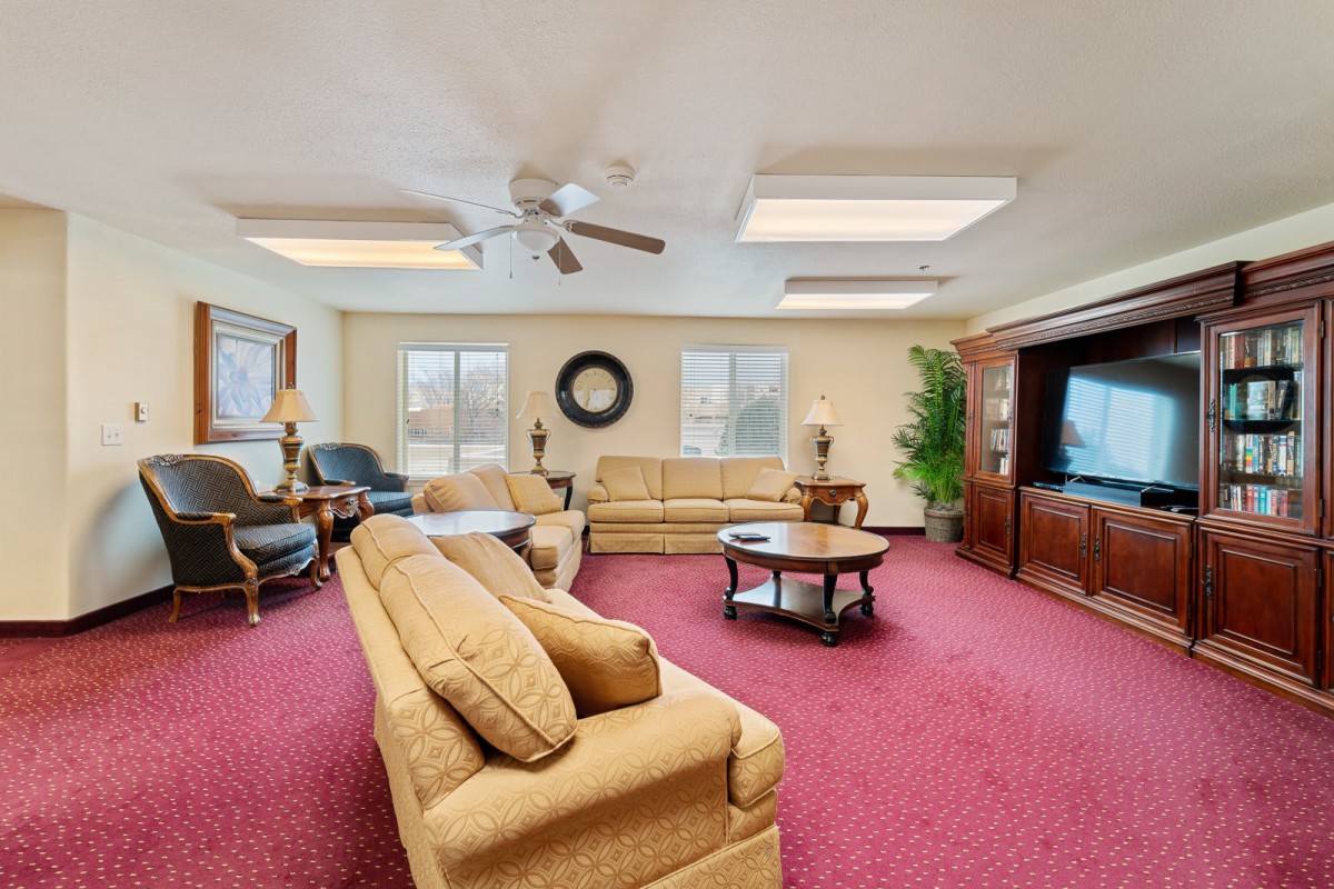 A spacious living room with comfortable seating, a large TV, and natural light.