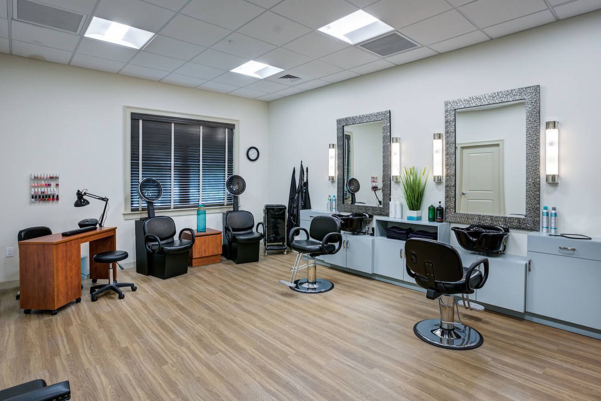 A modern hair salon with stylish chairs and mirrors in a well-lit room.