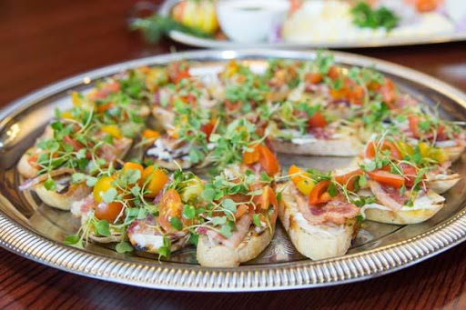 A beautifully arranged platter of colorful vegetable appetizers topped with fresh herbs and tomatoes.