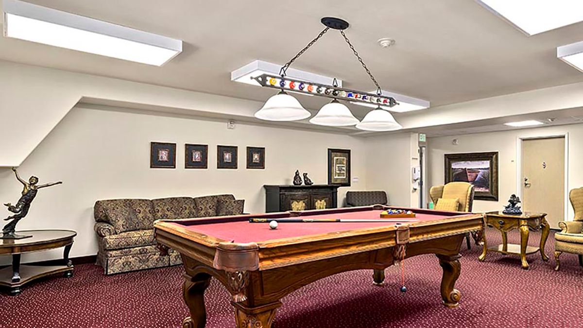 A cozy recreation room featuring a stylish pool table and comfortable seating.