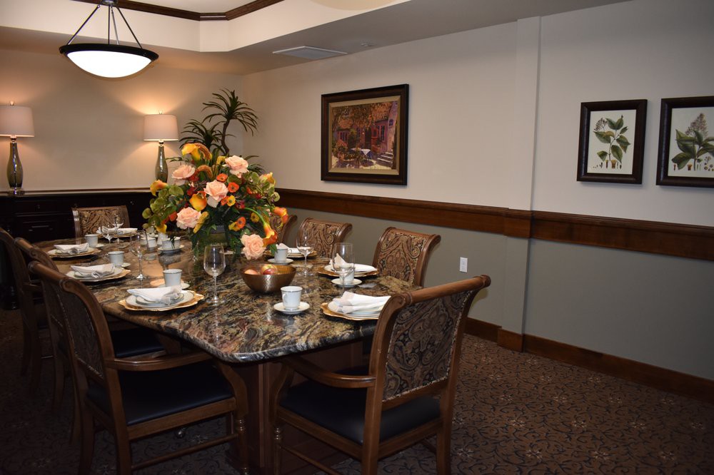 Elegantly set dining room with a floral centerpiece and artwork on the walls.