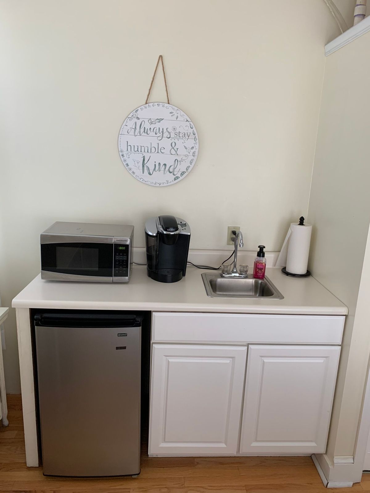 A compact kitchenette setup with essential appliances including a microwave, mini fridge, and coffee maker.