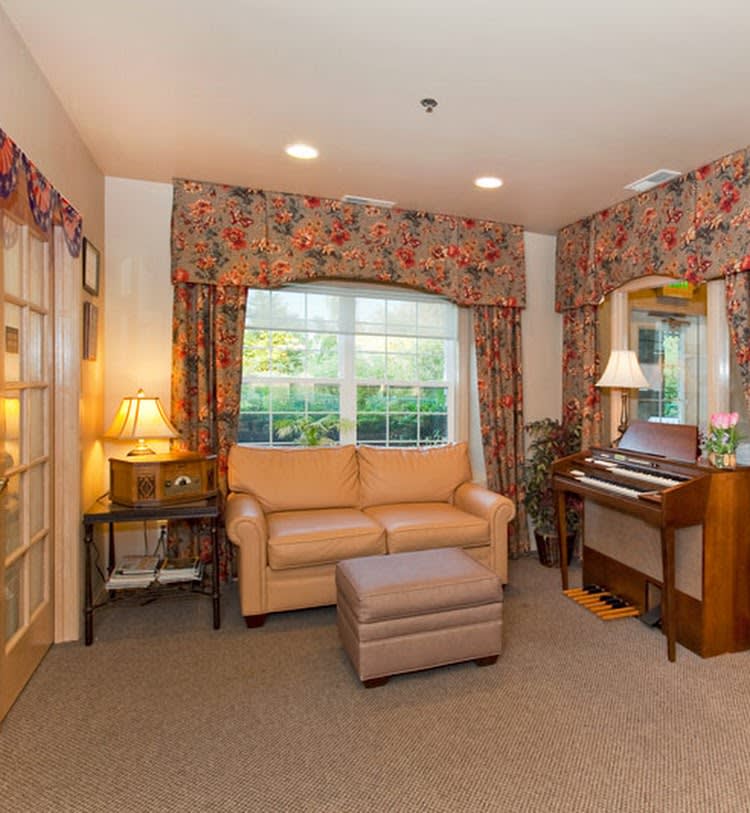 A cozy living room with a sofa, piano, and warm lighting.
