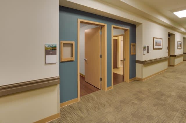 A hallway featuring open wooden doors and a blue accent wall.
