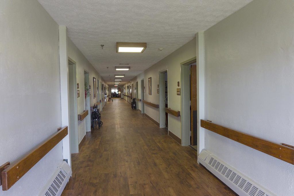 A long hallway in a hospital with doors on either side.