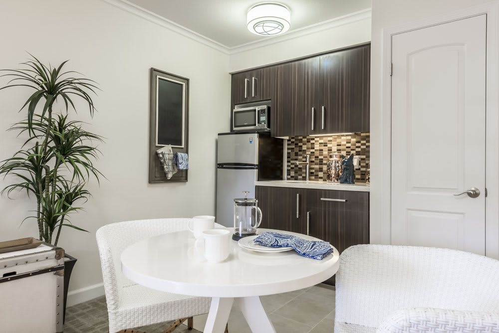 A modern apartment kitchen with a small dining area.