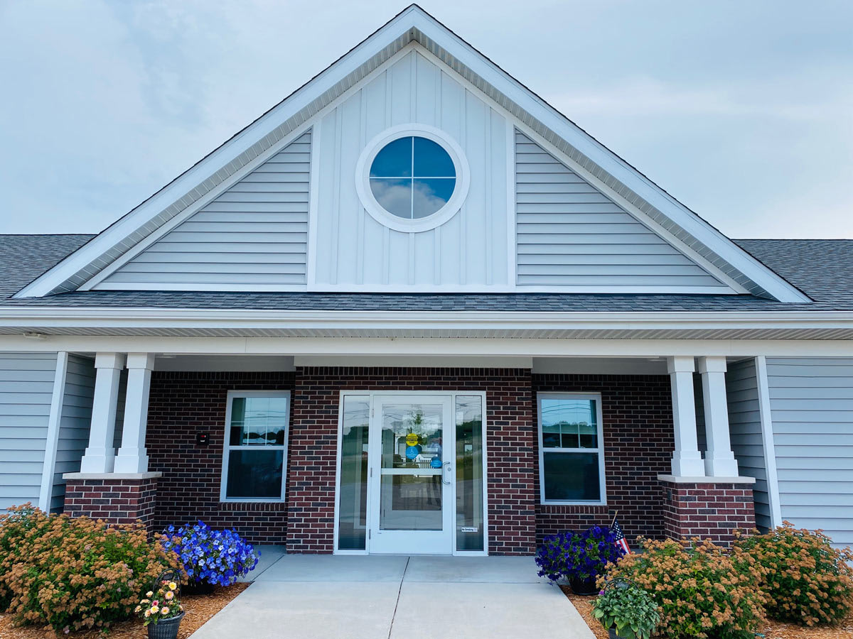 Front view of a building with brick exterior and a triangular roof.
