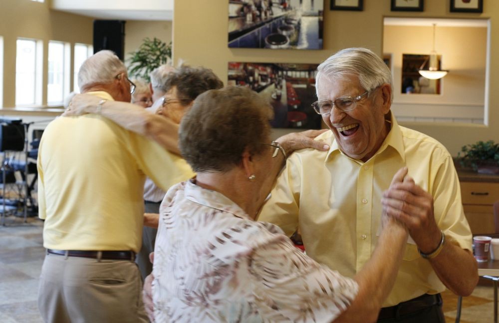 Senior couples enjoying a lively dance at a social gathering.