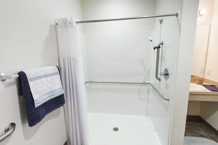 A modern bathroom with a shower and white curtain.