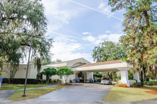 A welcoming entrance to a modern building surrounded by lush greenery.