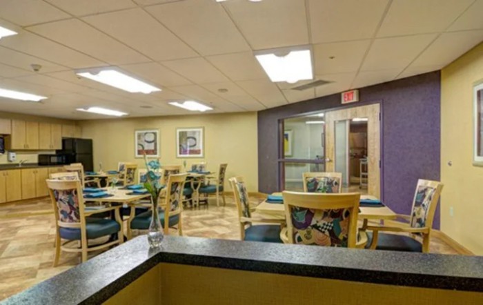 An empty dining area with several tables and chairs, featuring modern decor.