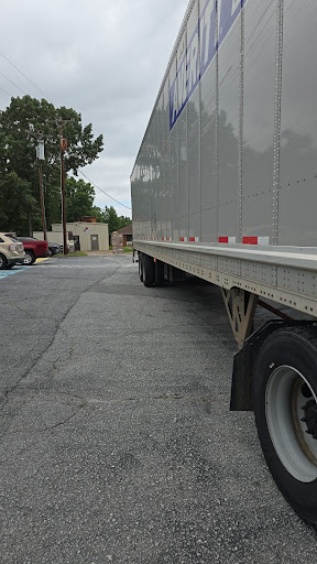 A side view of a large trailer truck parked on a street.