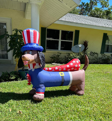 A playful inflatable dog dressed as Uncle Sam, adding a festive touch to the yard.