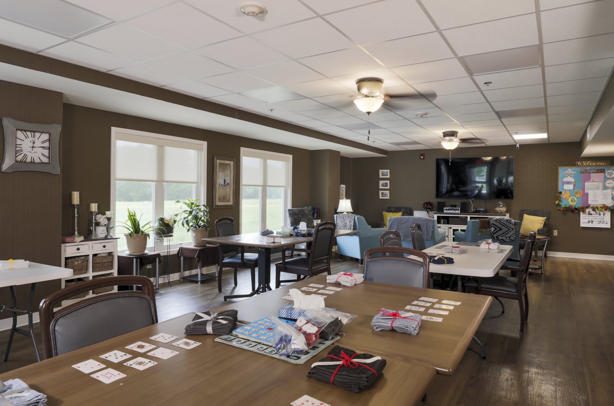 A cozy common area with tables, chairs, and a television, ideal for gatherings or activities.