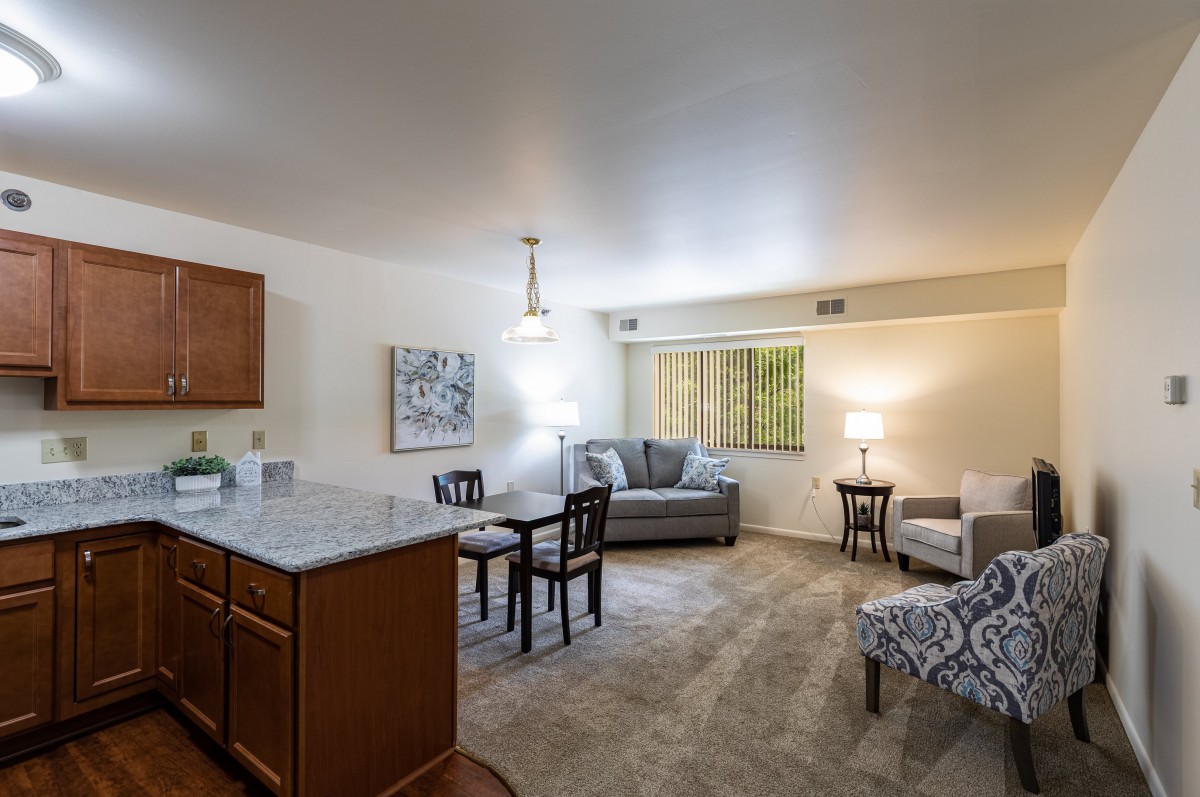 A cozy living room with an open space concept featuring a sofa, dining table, and modern furniture.
