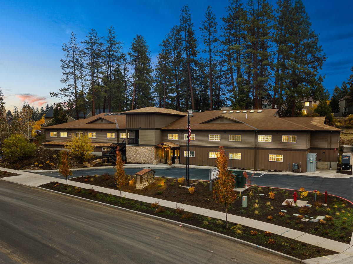 A modern building surrounded by trees during the evening.