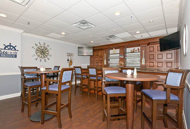 A cozy restaurant interior with tables, chairs, and a bar area.