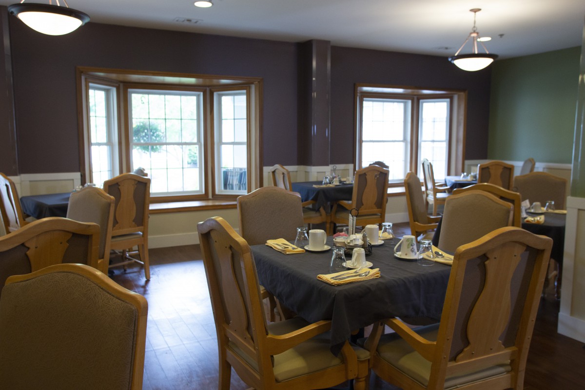 An empty dining room with tables set for meals.