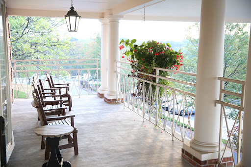 A serene balcony setting with wooden chairs and vibrant plants, perfect for enjoying the views.