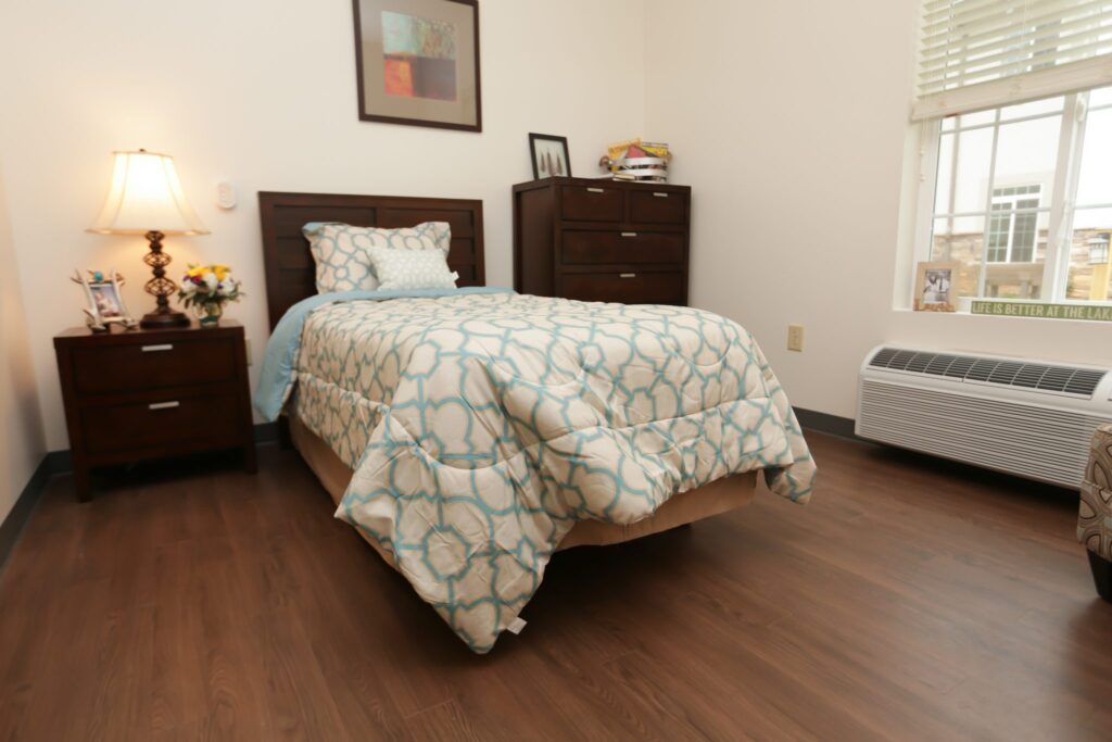 A cozy bedroom with a single bed, dresser, and soft lighting.