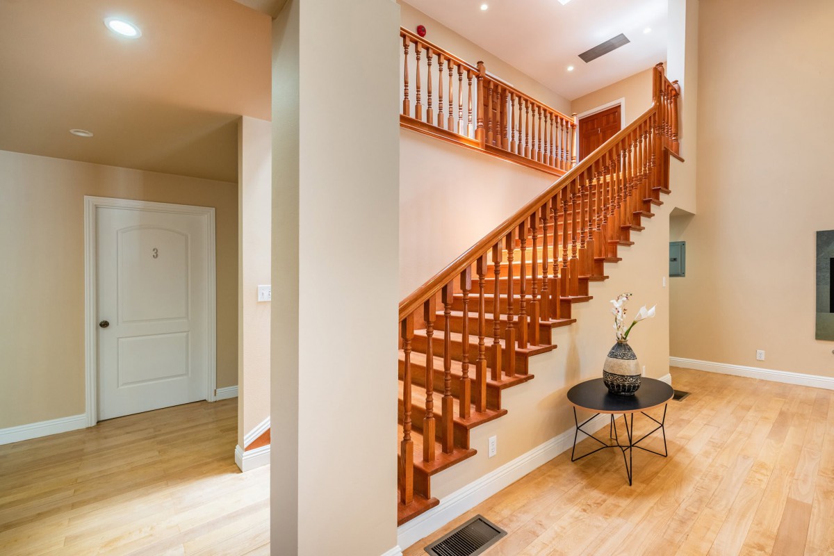 A modern home interior featuring a beautifully crafted wooden staircase and elegant decor.