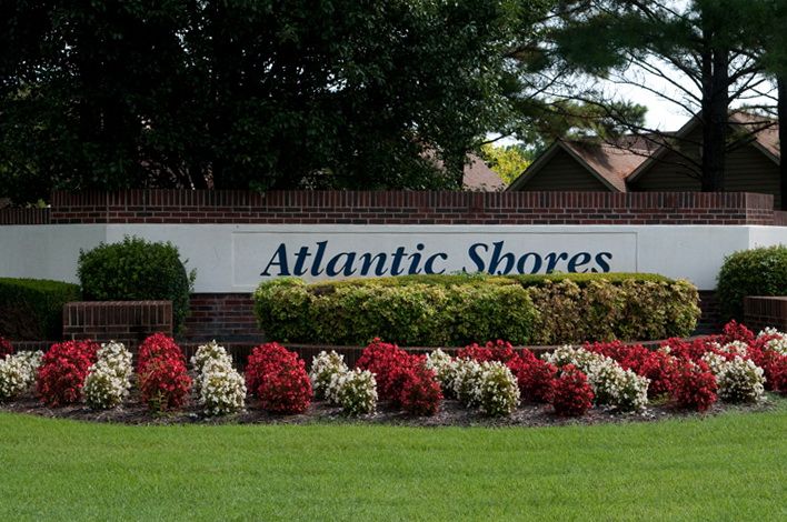 A beautifully landscaped entrance sign for Atlantic Shores, surrounded by vibrant flowers.