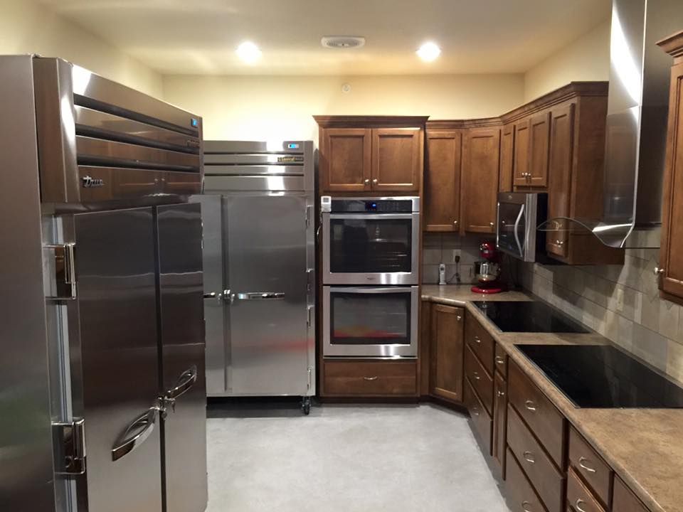 Modern kitchen with wooden cabinets, stainless steel appliances, and double ovens.