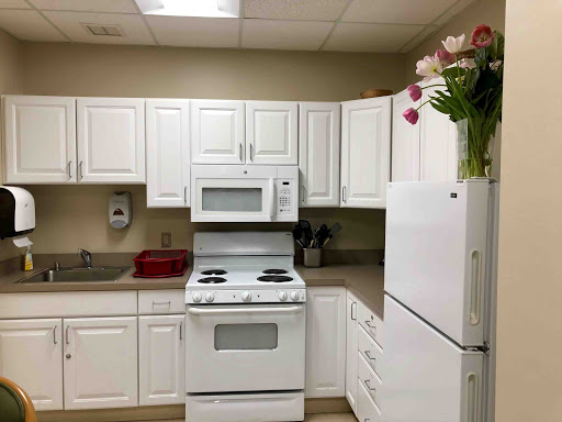 A clean and modern kitchen setup featuring white cabinetry and appliances.